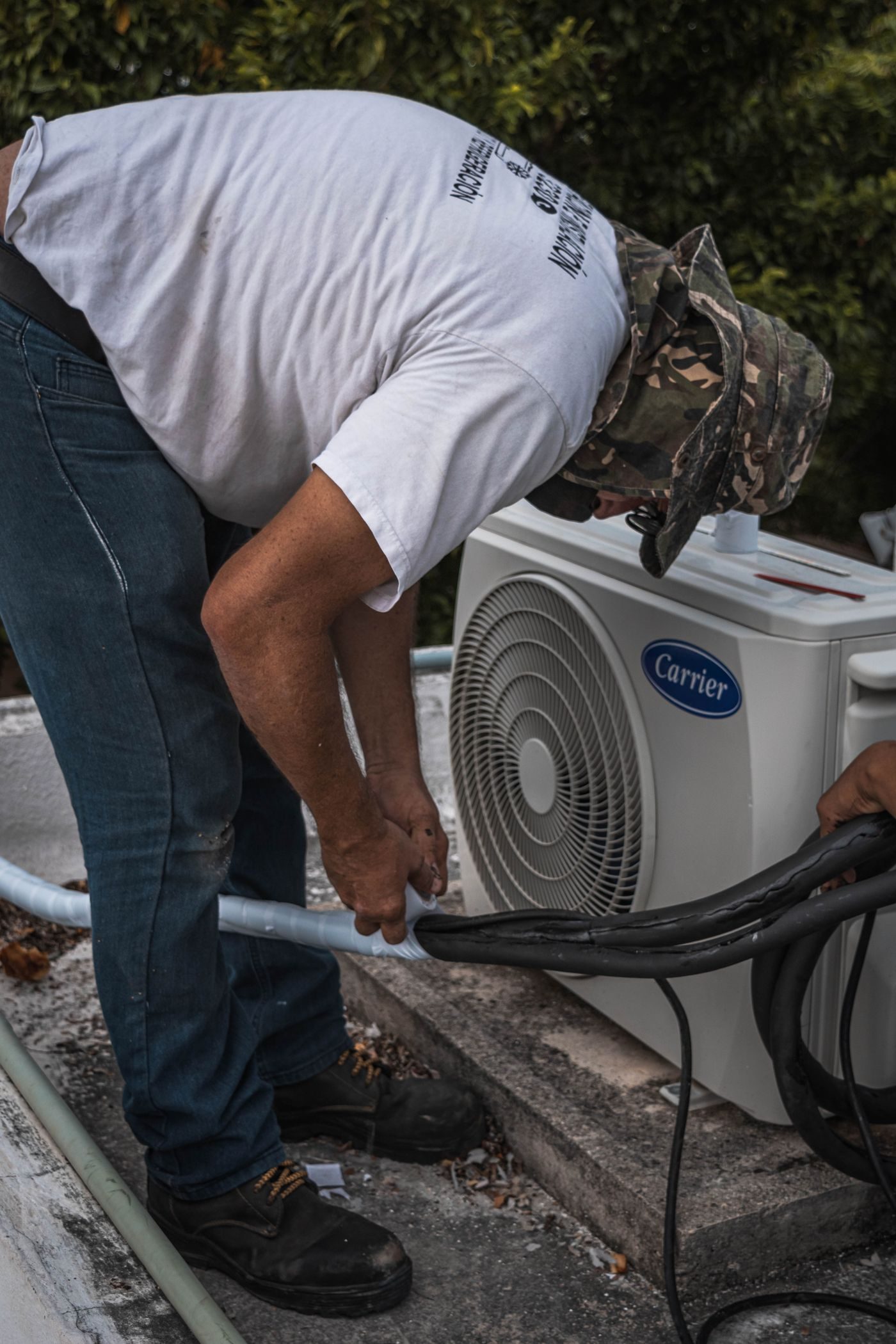 Technician performing maintenance on an outdoor condenser