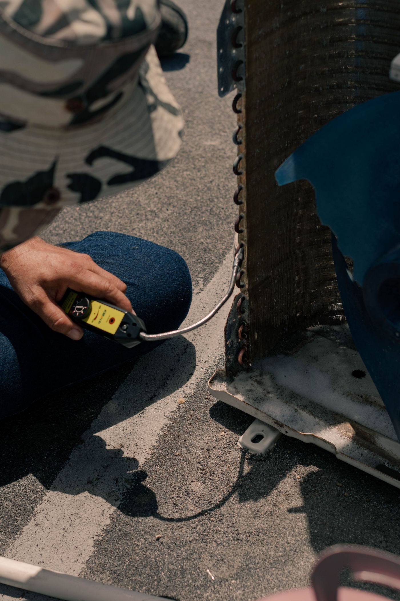Technician checking an AC unit with a diagnostic meter